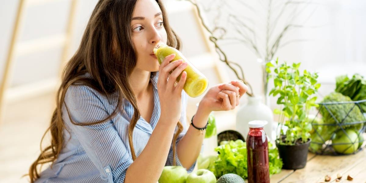 egy nő zöld smoothie-t iszik